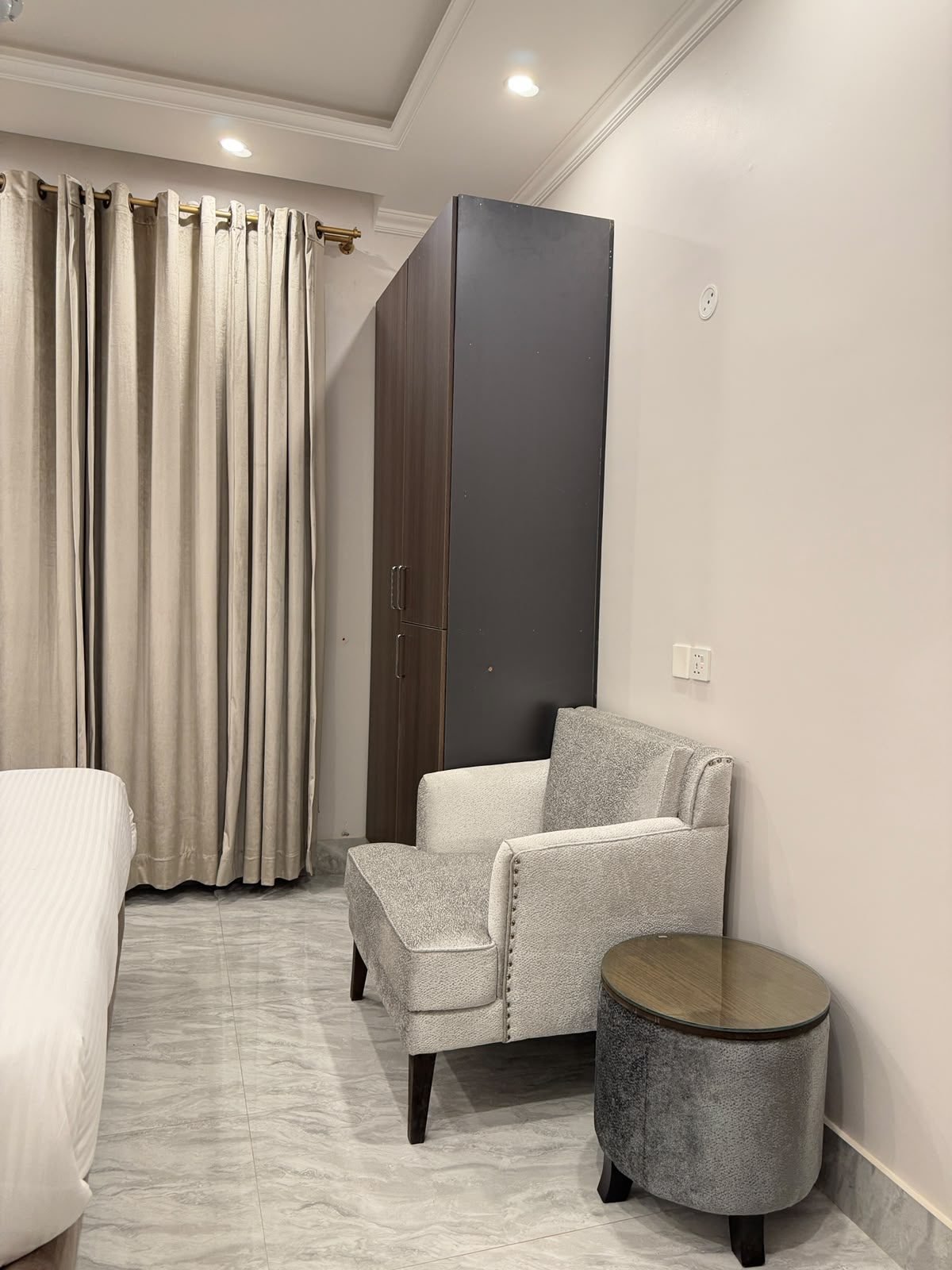 Junior Suite bedroom with seating at Regency Suites Hotel, 48 Baloch Road, Gulberg III, Lahore