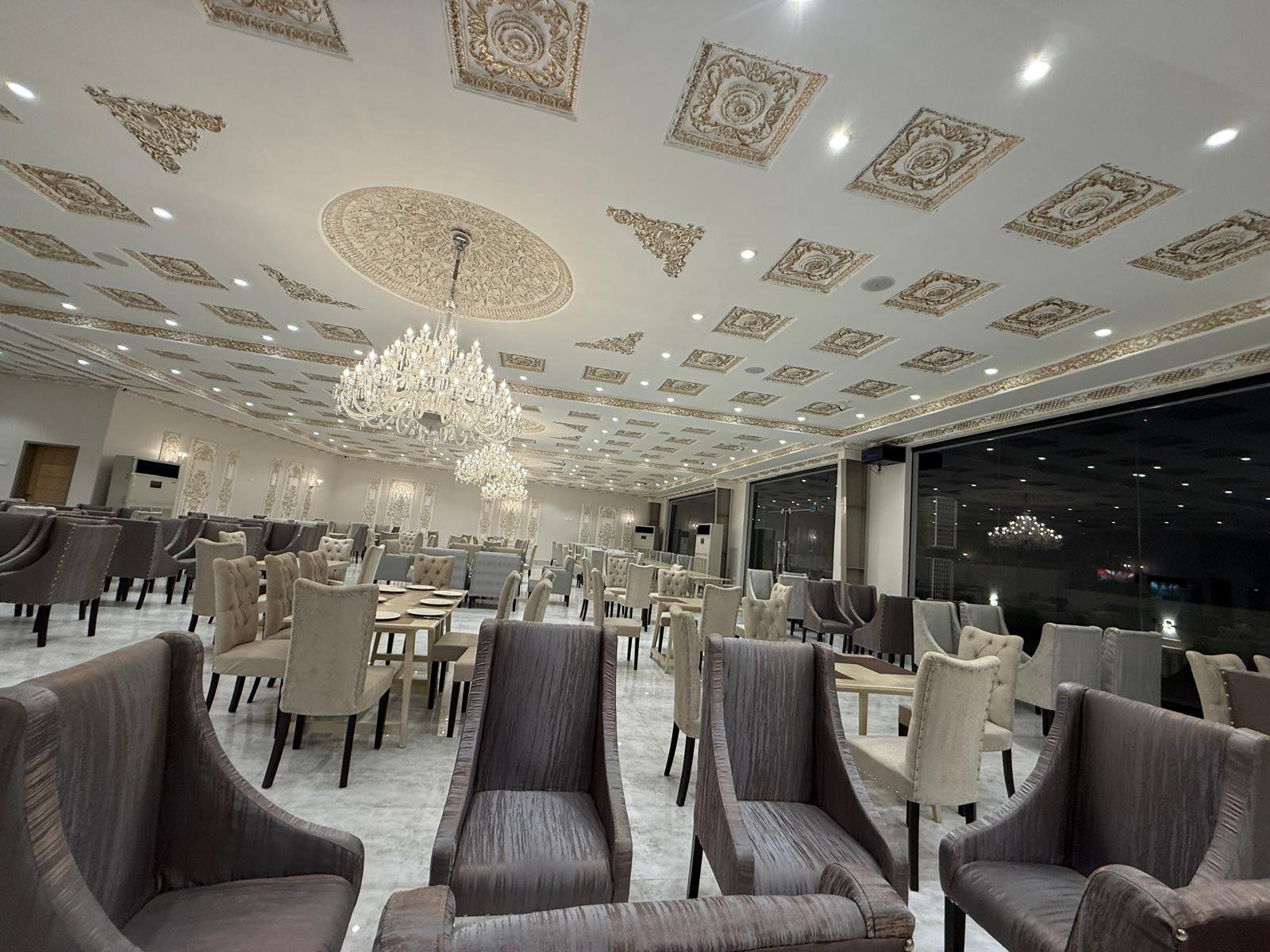 Darbar hall set with dining chairs under chandeliers, Gulberg III Lahore